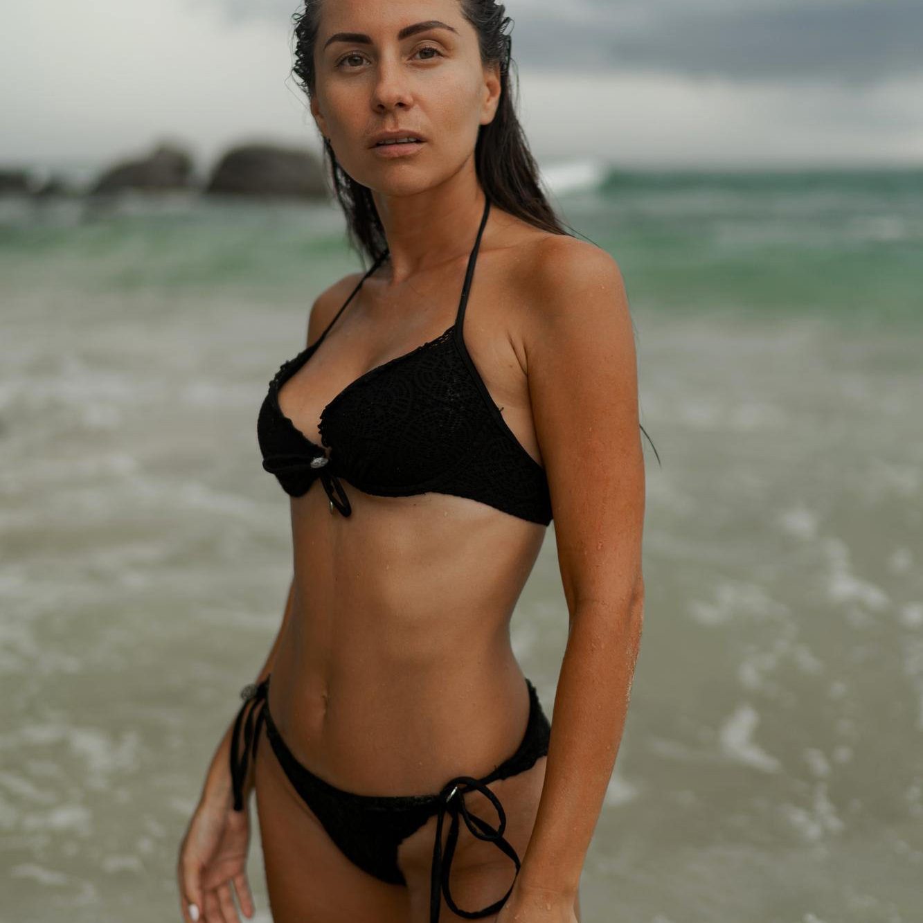 gorgeous-brunette-woman-with-perfect-figure-posing-tropical-beach-wearing-stylish-black-swimwear